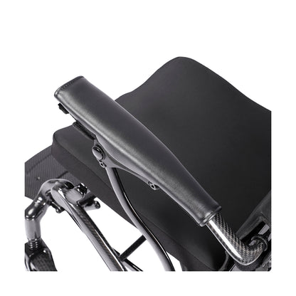 A detailed top-down view of the Harvey Carbon power wheelchair's armrest, highlighting the carbon fiber support tube with its distinct weave pattern and the smooth, ergonomic black padding on top.
