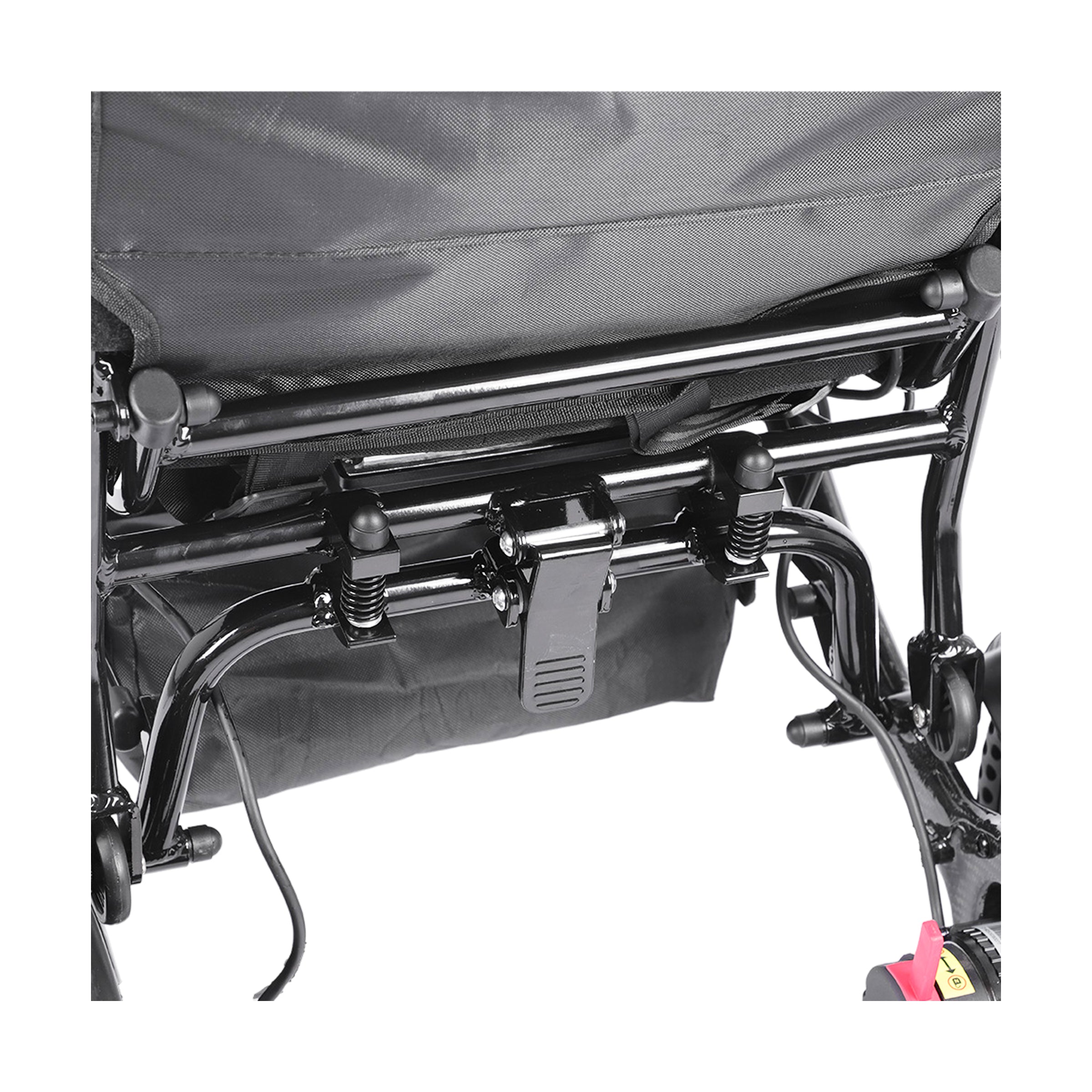 A close-up of the underside rear frame of Harvey Carbon power wheelchair, showing the heavy-duty black metal folding mechanism, suspension springs, and the quick-release latch used to collapse the wheelchair. 