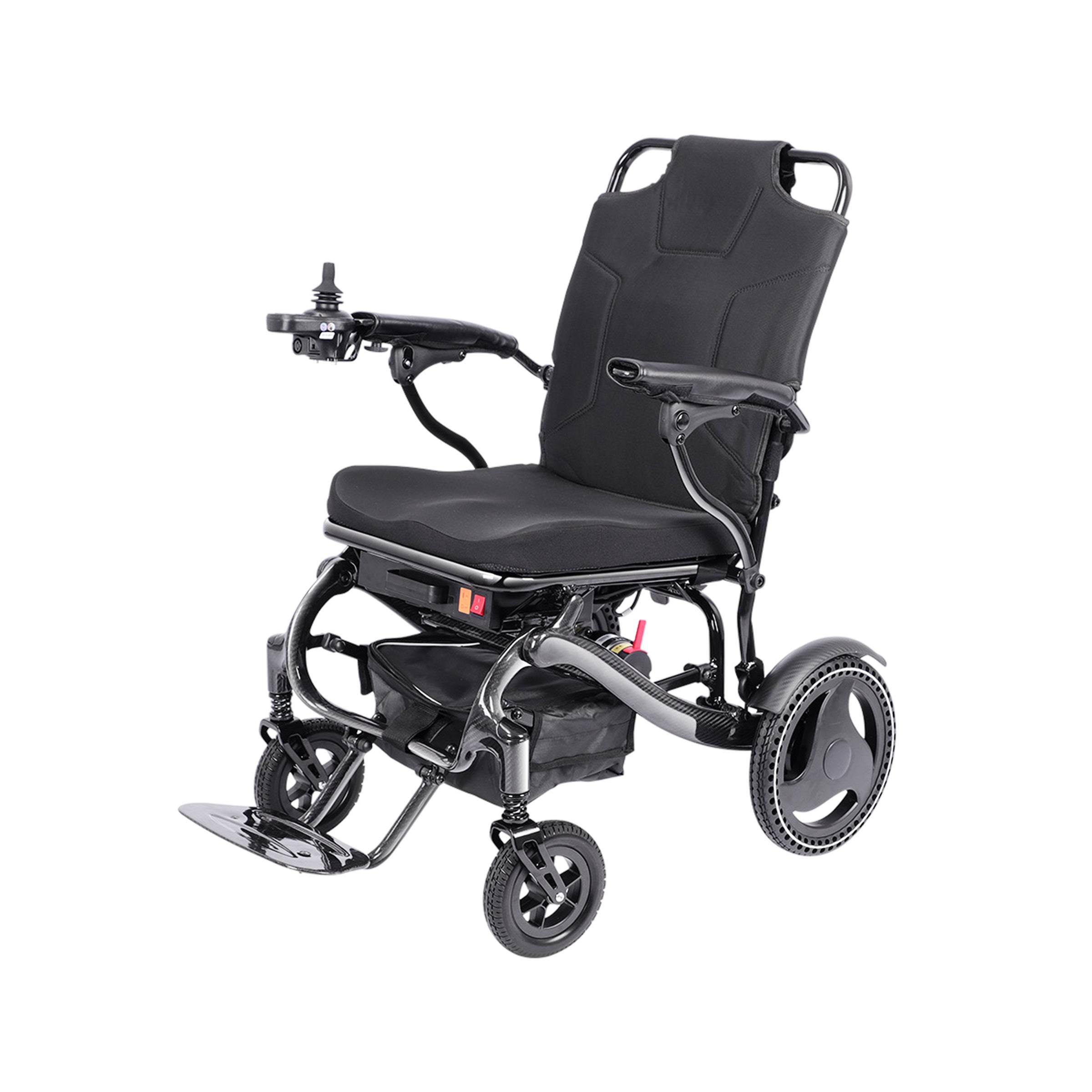 A front three-quarter view of the Harvey Carbon Power Wheelchair. The detailed carbon fiber texture is visible on the S-shaped frame and wheel arches. The padded black seating system with integrated top handles and curved armrests are shown. The joystick is on the right armrest. Dual small front casters are positioned under the metal footplate, with large drive wheels in the rear, set against a white background. The red power switch is visible beneath the seat.