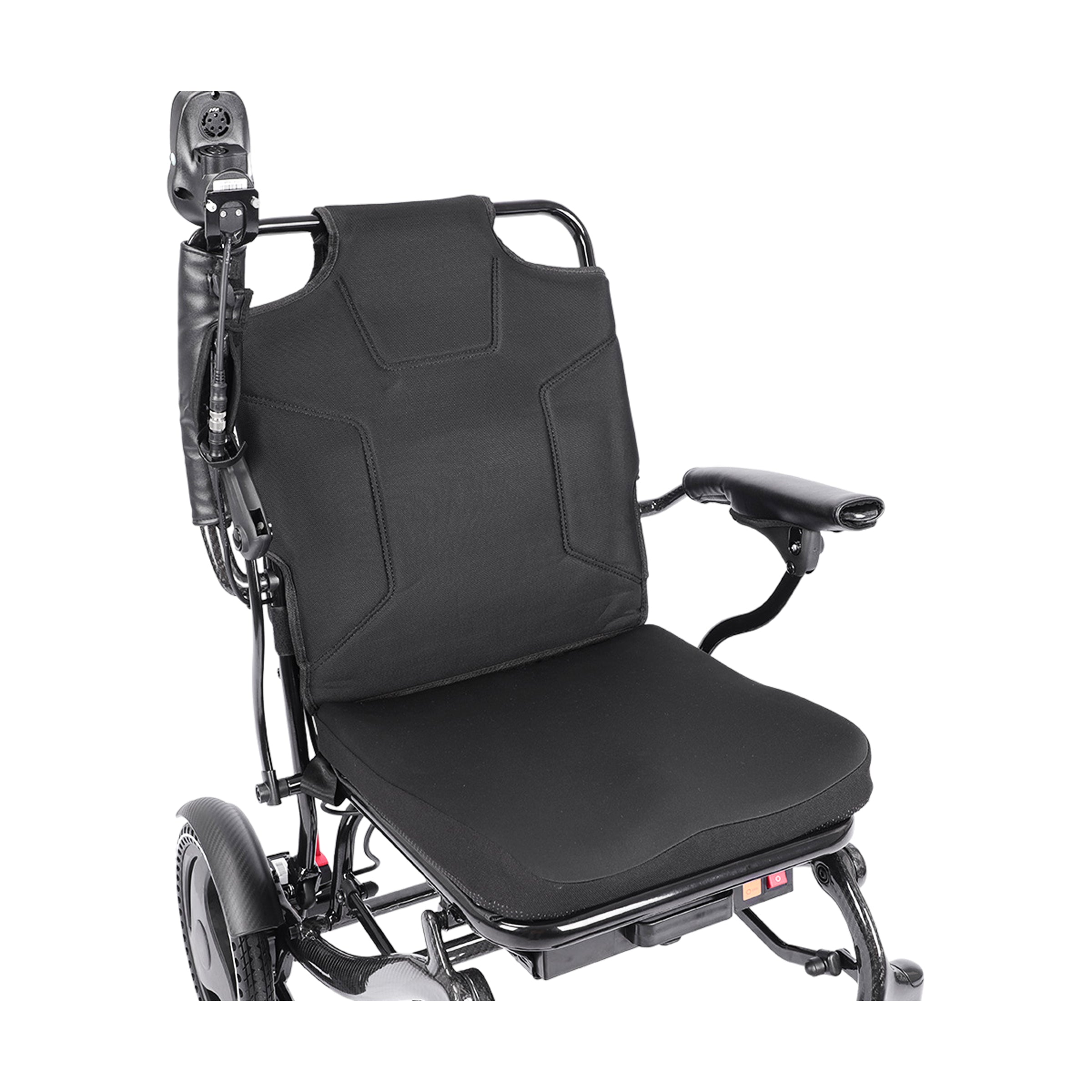 An angled top-down perspective view of the Harvey Carbon Power Wheelchair's seat and backrest. This view emphasizes the plush, black contoured cushion of the seat and backrest. A joystick is mounted on the right armrest, which has a protective sleeve on its base. The carbon fiber texture of the frame and a large drive wheel are visible. Below the seat, a storage pouch and the red power switch can be seen.
