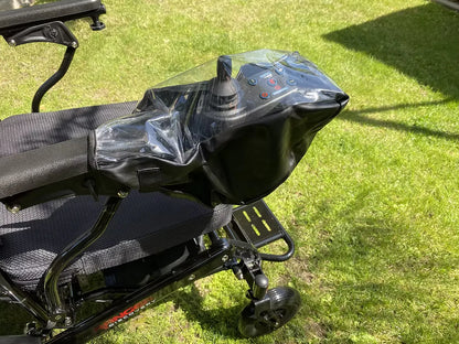 A Muvon Mobility joystick protective cover with a transparent top window and black waterproof base, shown shielding the power chair controls from the elements while maintaining full visibility.