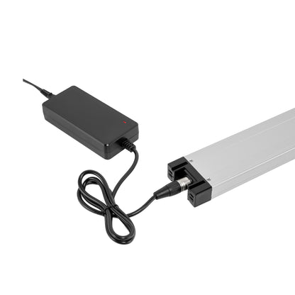 Close-up detail view of the Muvon Equinox power wheelchair battery component showing an AC power supply adapter and cord plugged in for charging.